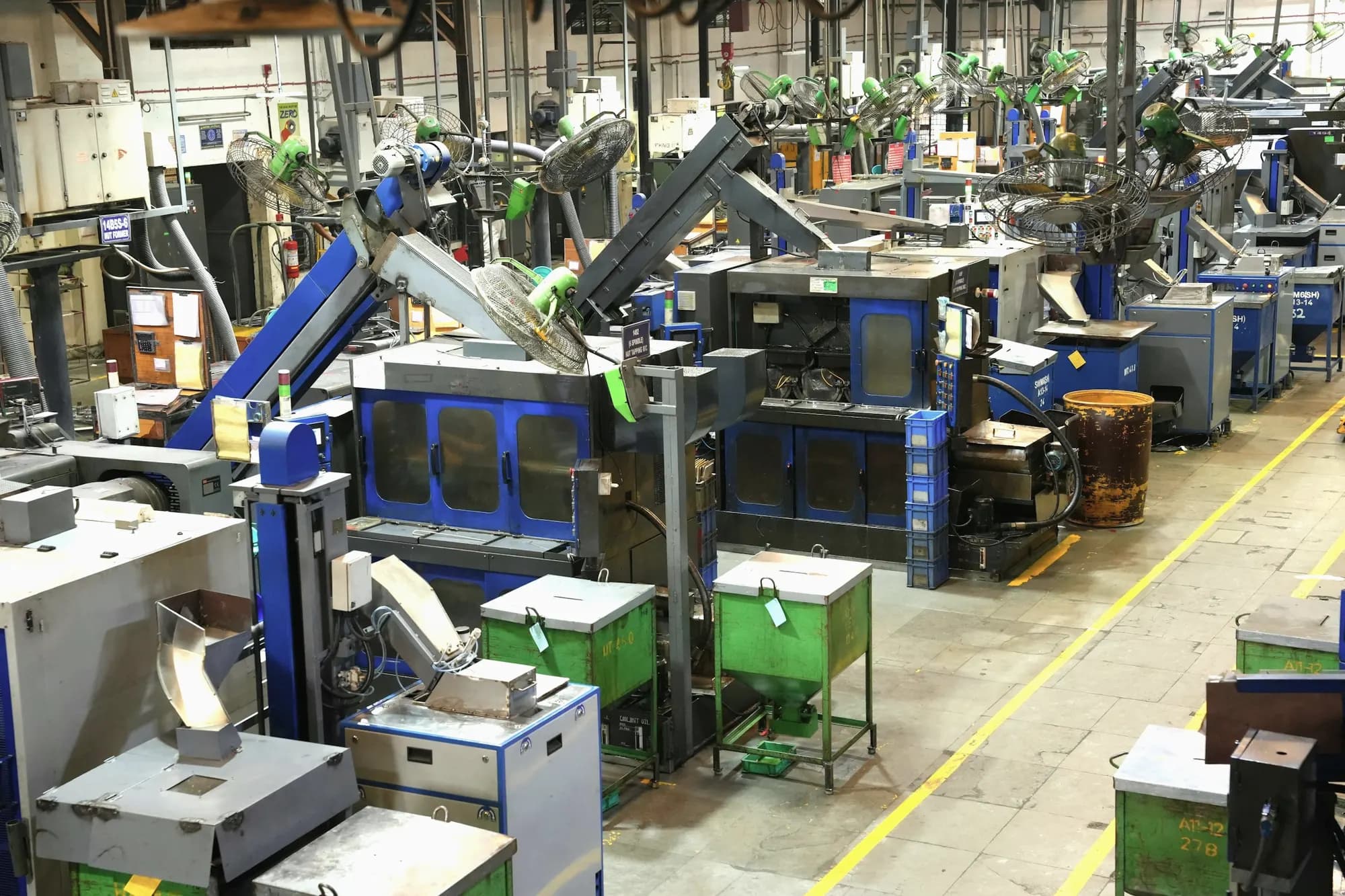 A machine shop floor with yellow walkway lines