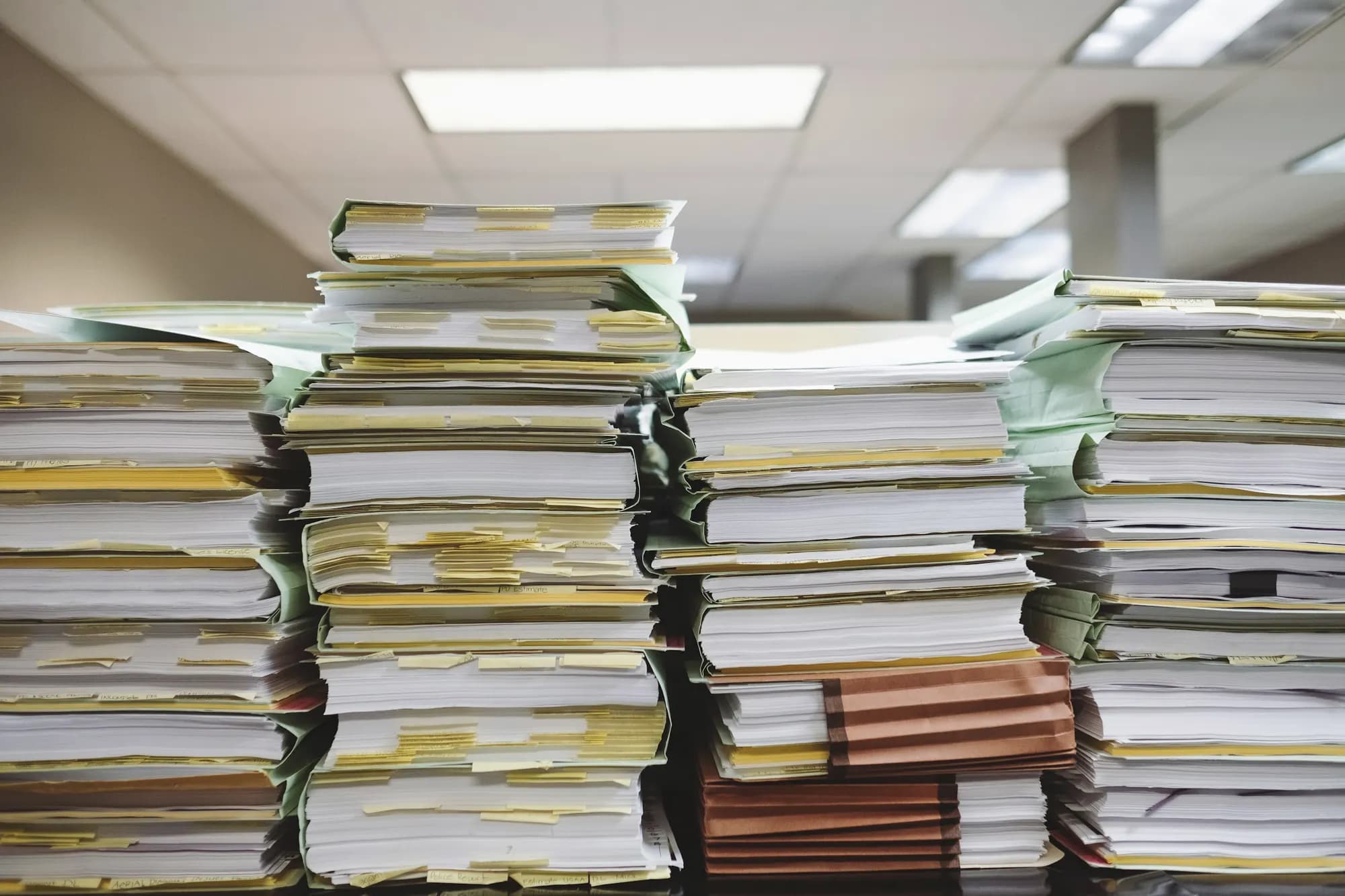 Stacks of paper case files with coloured index tabs