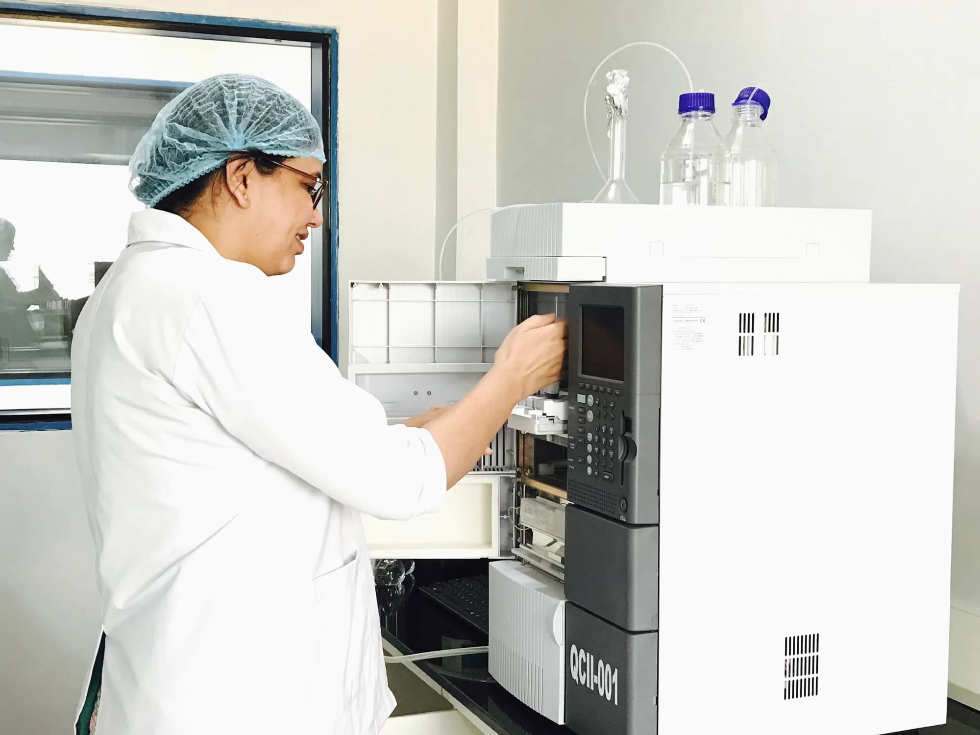 An analyst at a chromatography instrument in a laboratory